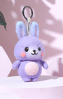 Front view of handcrafted needle-felted purple bunny keychain standing on a pink platform, featuring a durable black metal ring and white Woobbi brand tag.